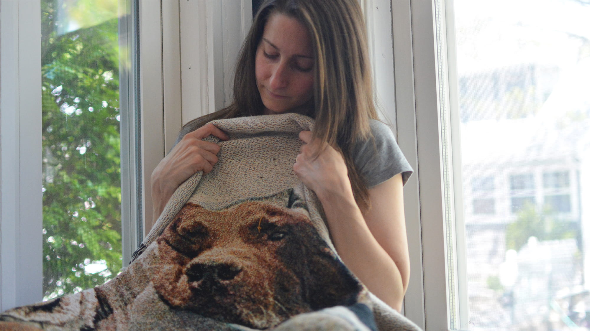 Woman holds blanket with image of dog